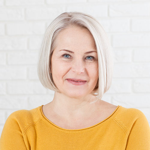 Middle-aged woman in a gold sweater.
