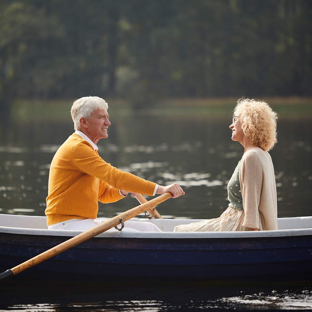 Senior couple rowing a boat on the lake